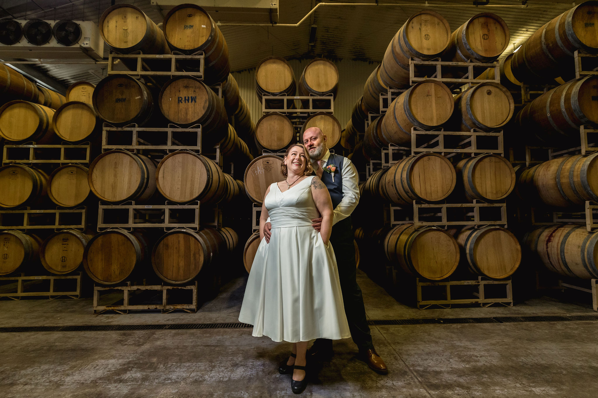 a couple poses in a wine cellar at duchman winery for their wedding day