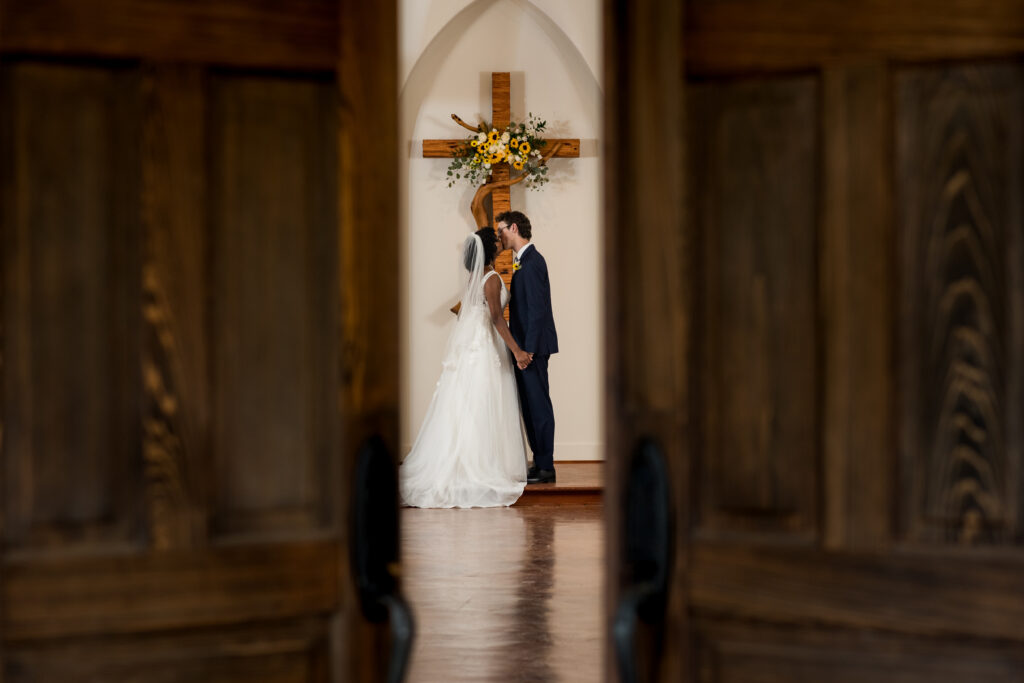 Austin bride and groom share first kiss in sunflower-adorned chapel.