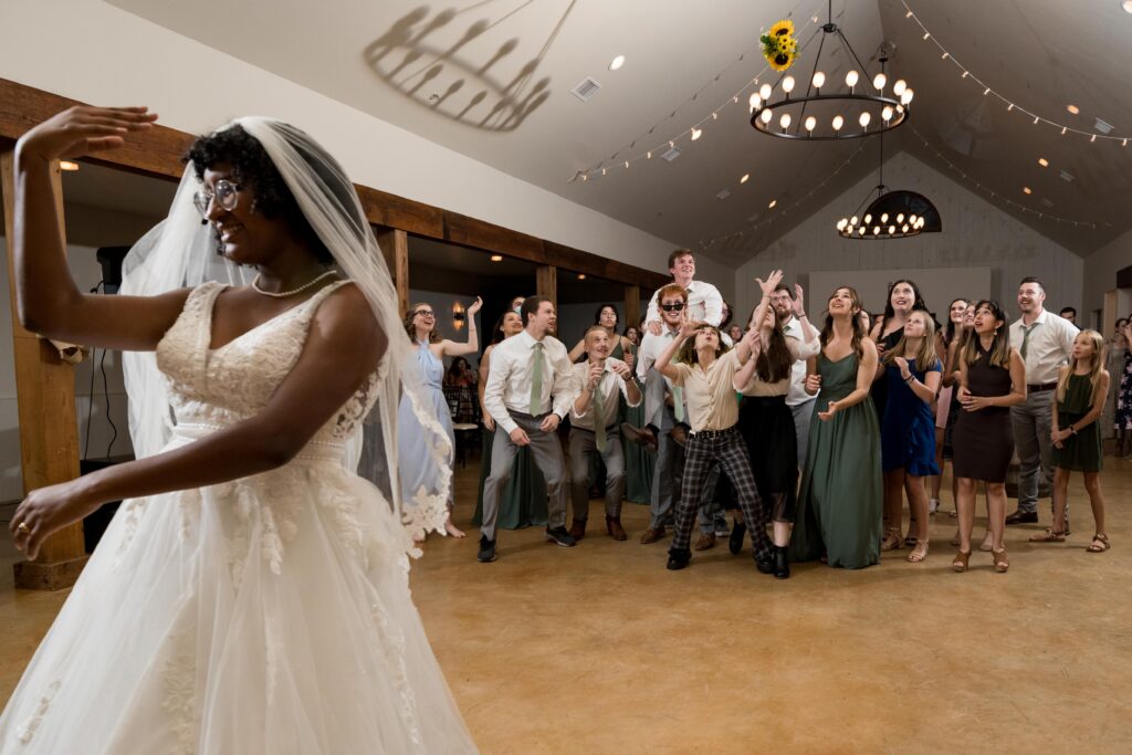 Bride tossing bouquet to wedding guests in reception.