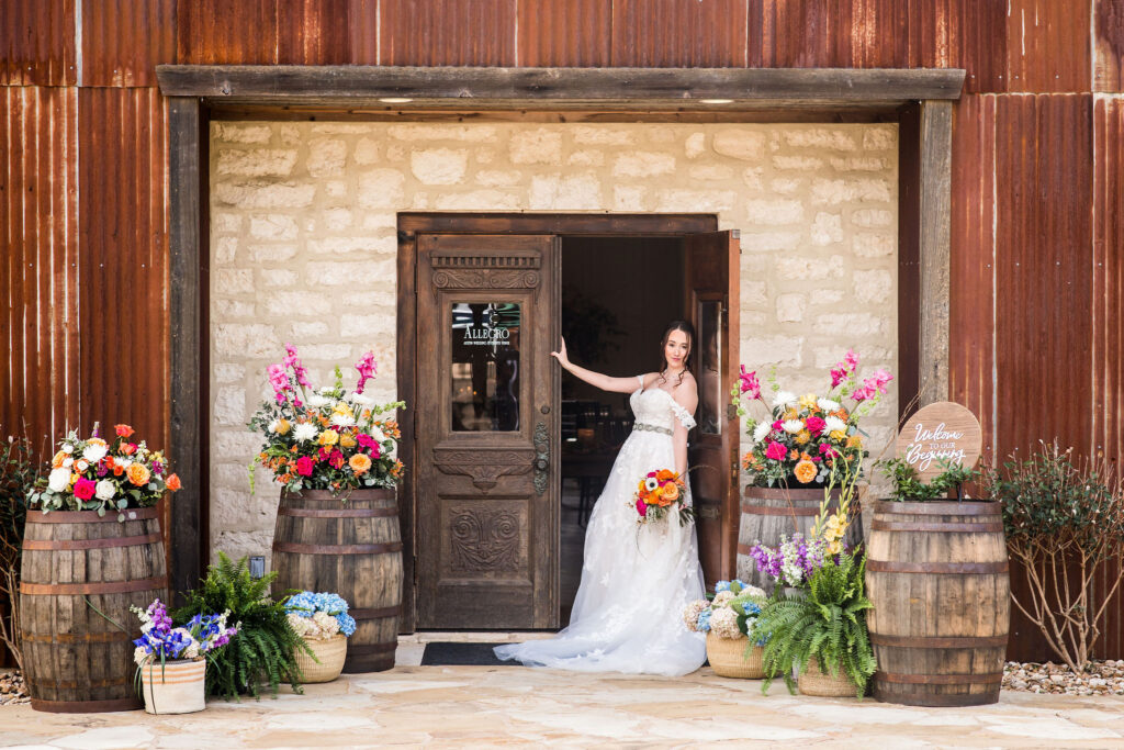 a bride leans against a wooden door at Allegro Wedding Events Venue
