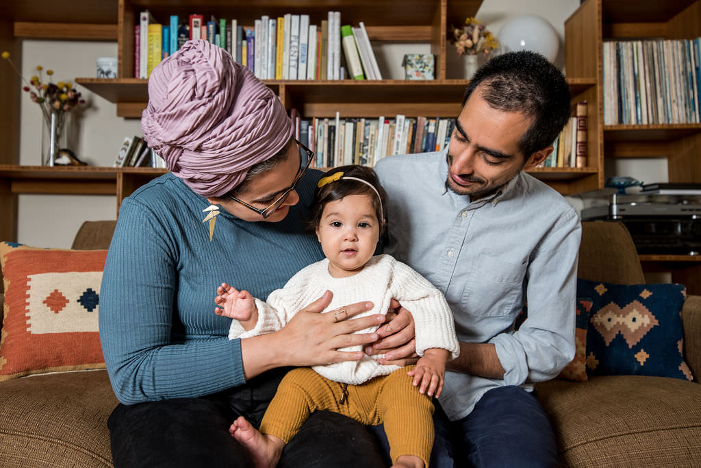a family cuddles with their baby for their lifestyle family photography session at their home