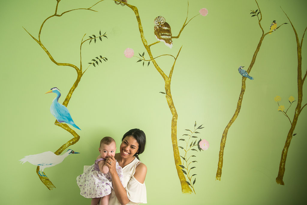 a mother holds her baby in their nursery at home for their lifestyle portraits