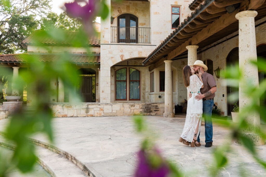 an engaged couple cozy up on the patio at The Garey House, a wedding venue in Georgetown, TX