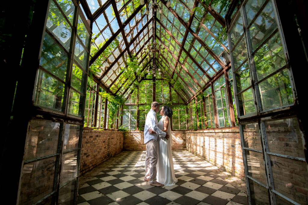 a black couple dance holding one another in a green house during their 25th anniversary. 
